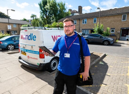 Wandle repairs colleague smiling front van