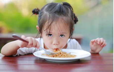 Young child eating spaghetti